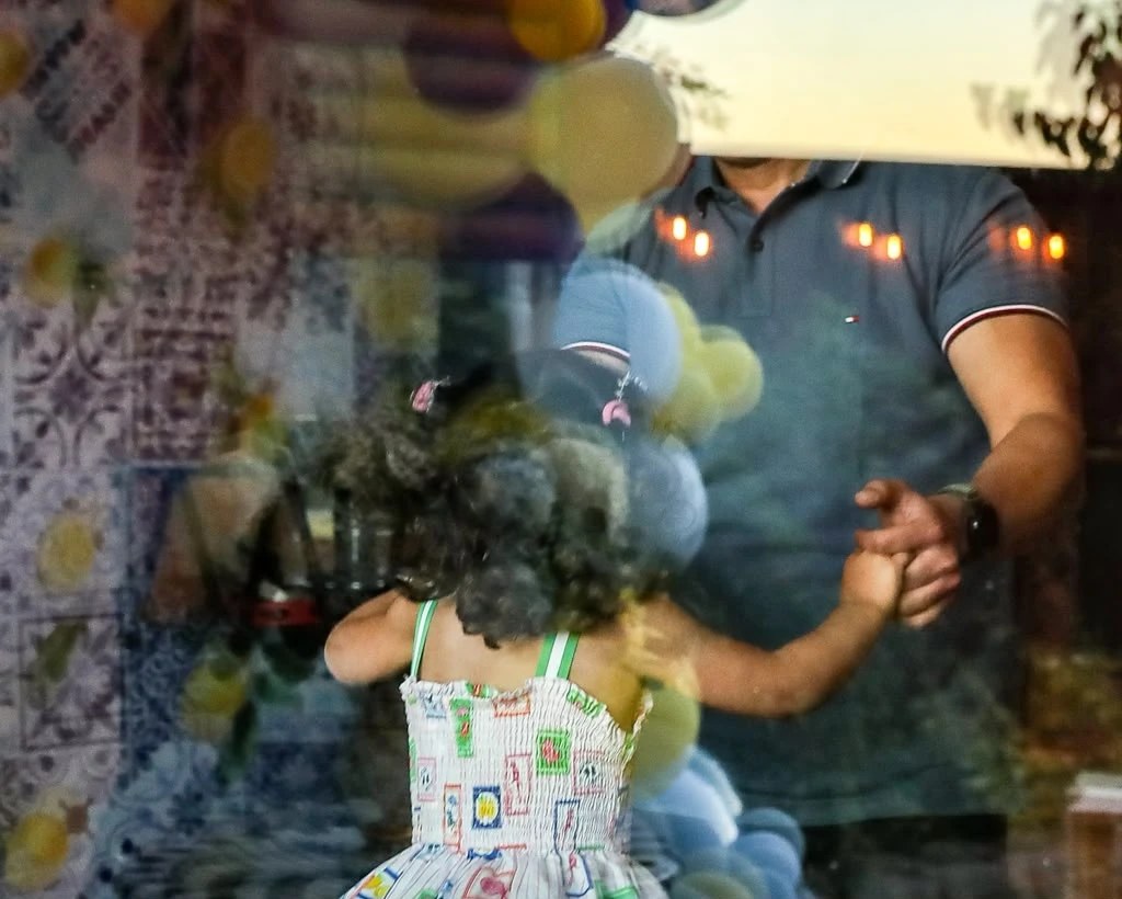 DJ Alphire dancing with a young guest at a balloon-decorated birthday party