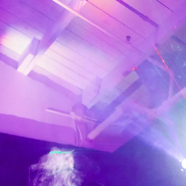 Purple lighting and haze over the crowd at a Bay Area event