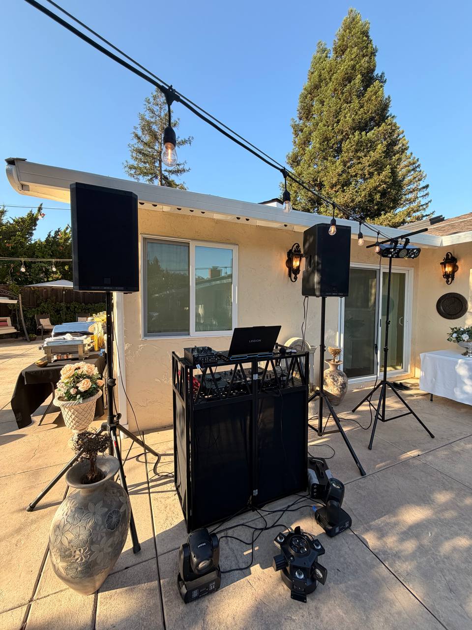 DJ Alphire's full sound and lighting setup with moving head lights at a backyard event