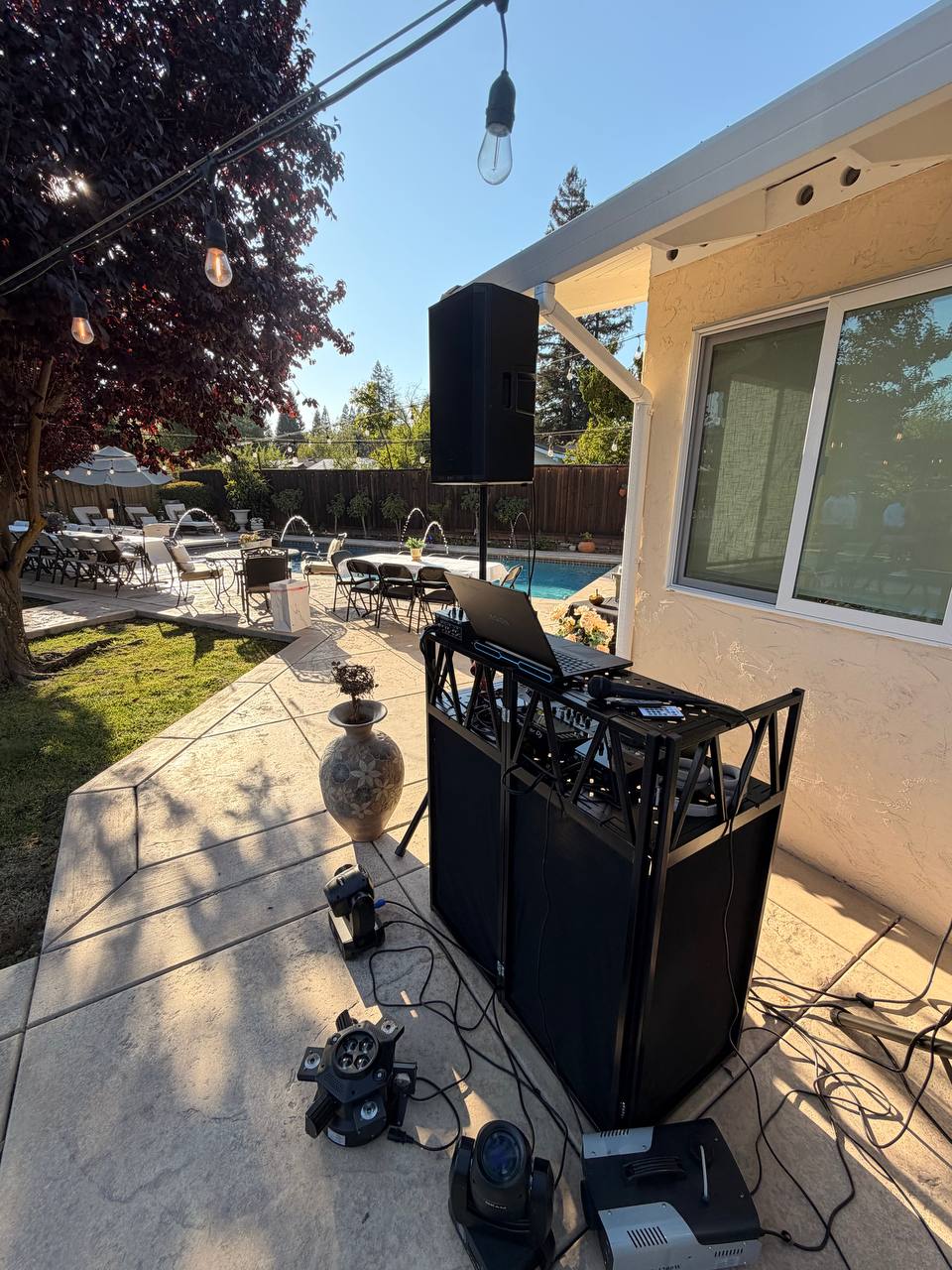 DJ Alphire's booth and speaker setup poolside at golden hour