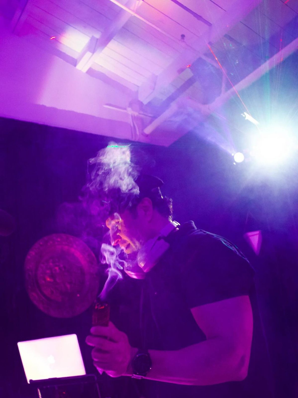 DJ Alphire behind the decks under purple lighting at a Bay Area event