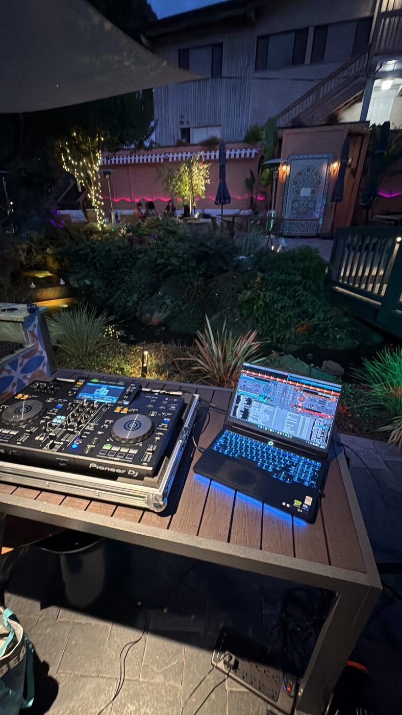 DJ Alphire at an outdoor garden party with Pioneer CDJ setup