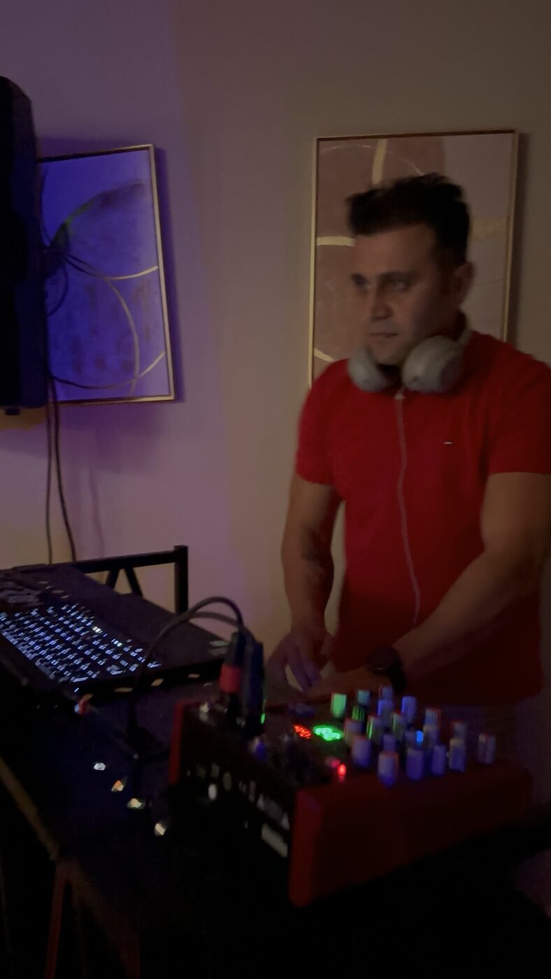 DJ Alphire at the decks with crowd under red venue lighting