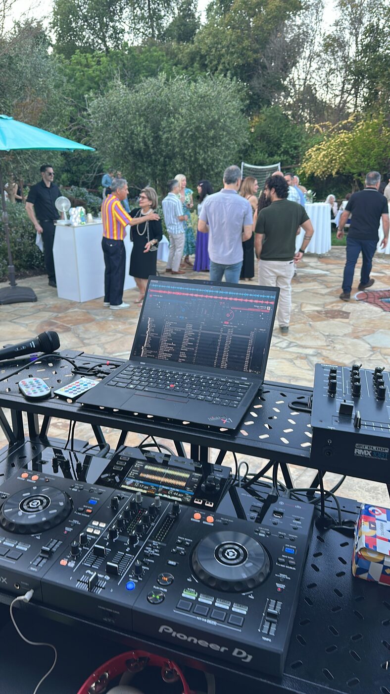 DJ Alphire's Pioneer DJ setup at an outdoor gathering with guests